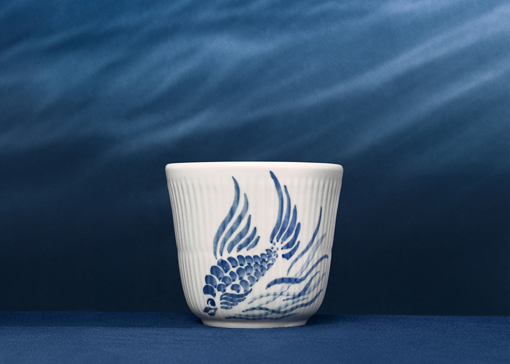 The blue fish on the A Majestic Tale anniversary cup from Royal Copenhagen.